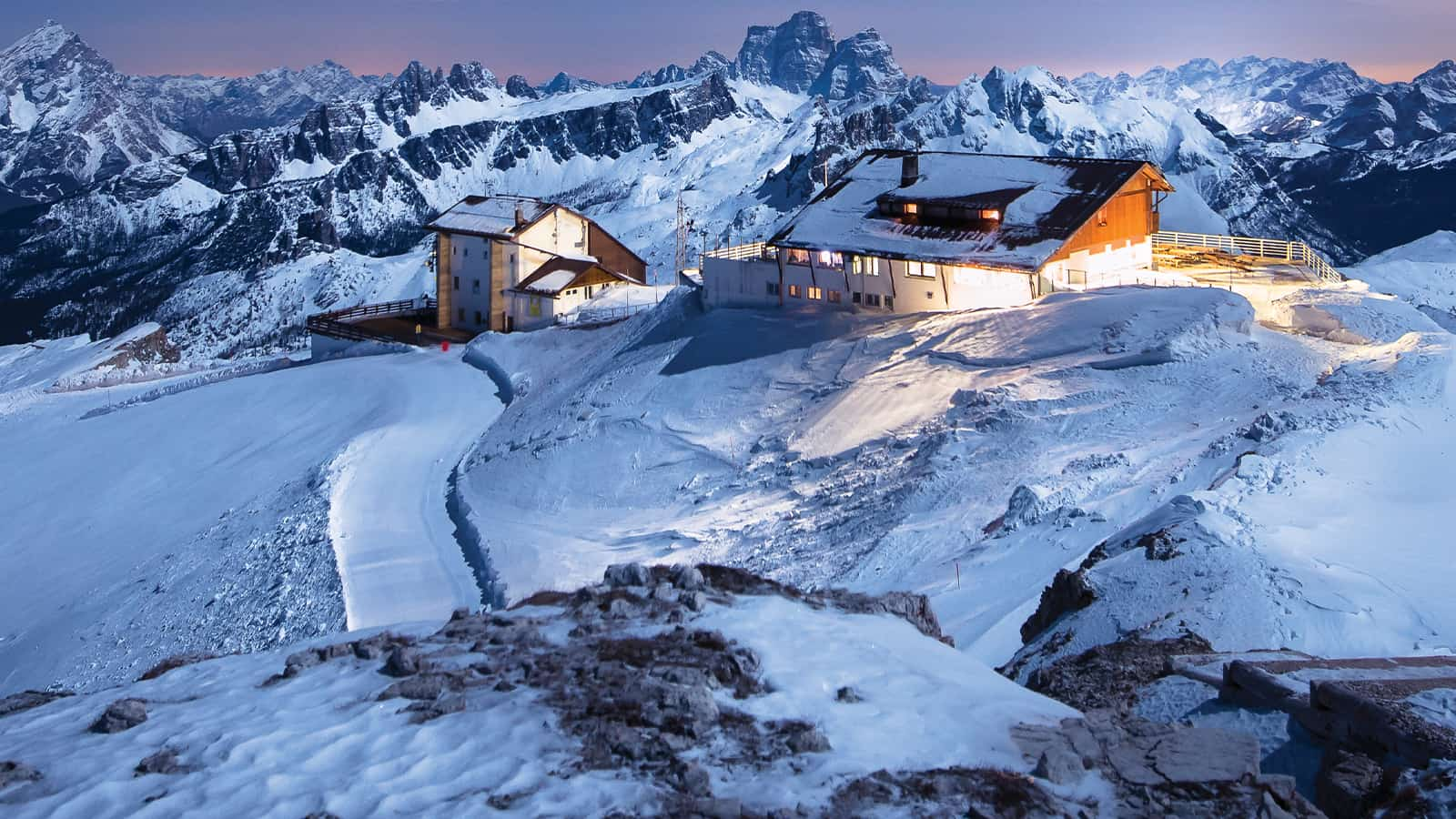 Cabines au sommet d’une haute montagne avec feux brillants allumés.