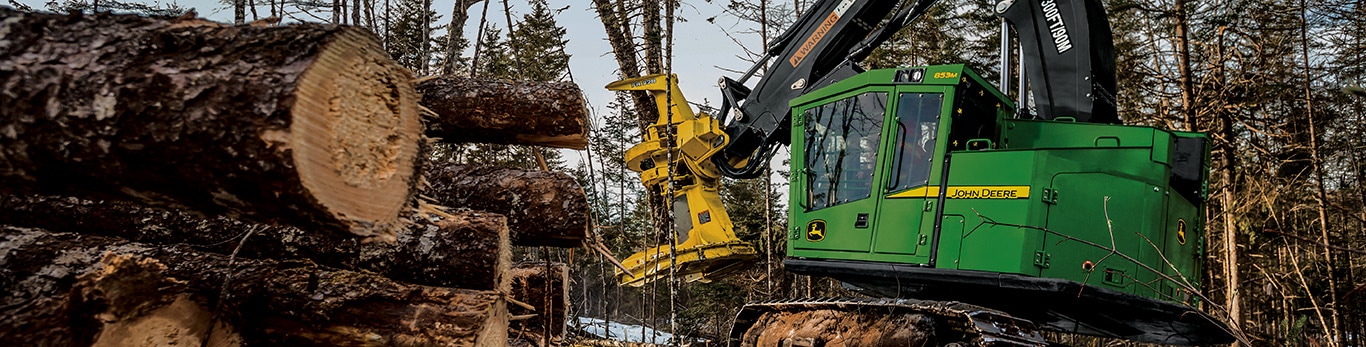 Une abatteuse-groupeuse 853M abattant des arbres dans les bois avec une tête FR22B