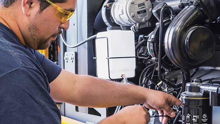 un homme avec des lunettes de sécurité travaillant sur un moteur
