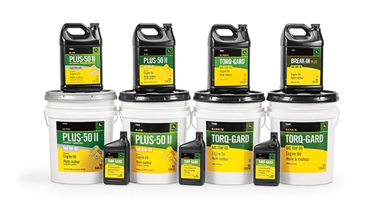 photo de studio de divers bidons d’huile John Deere empilés