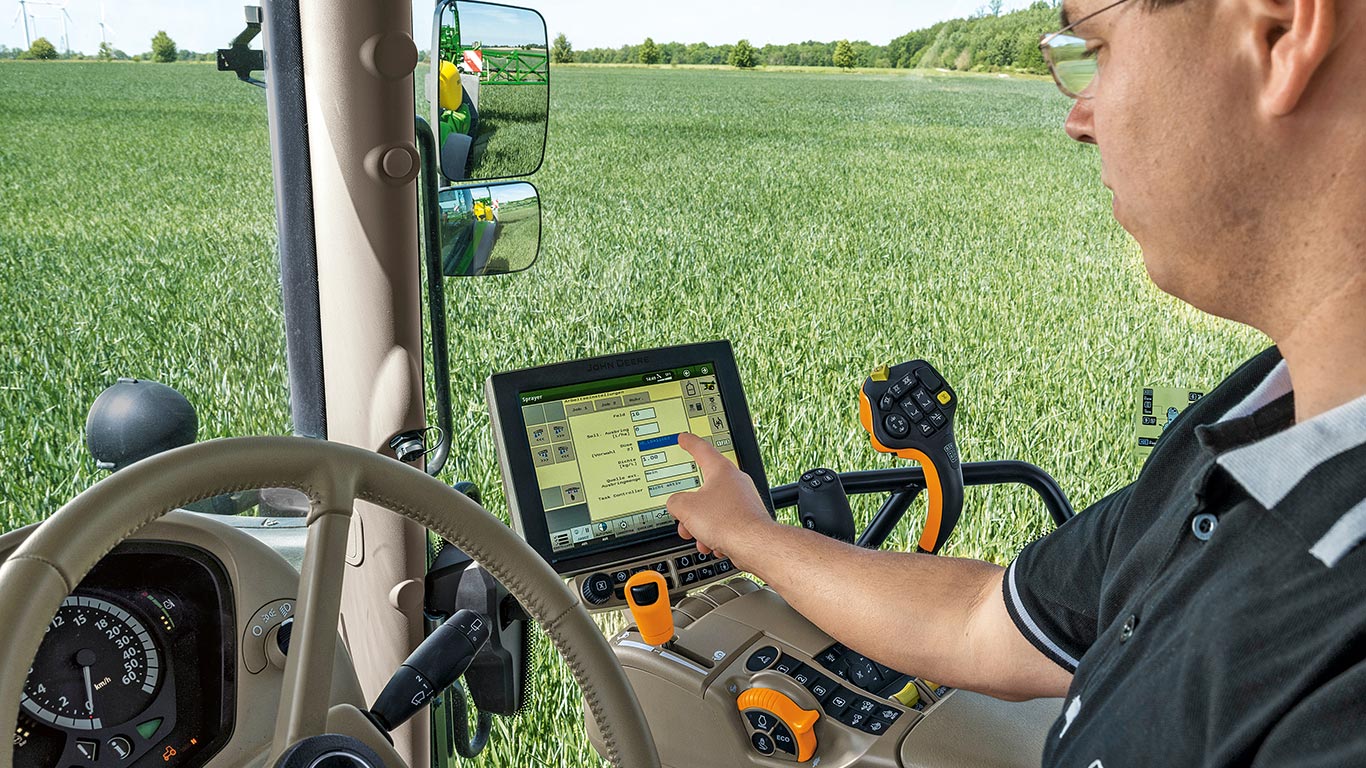 Homme dans un tracteur utilisant un écran tactile