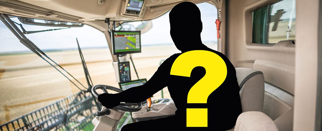 Interior view of a combine cabin with advanced control screens and steering wheel, featuring a silhouette with a yellow question mark indicating an unknown operator.