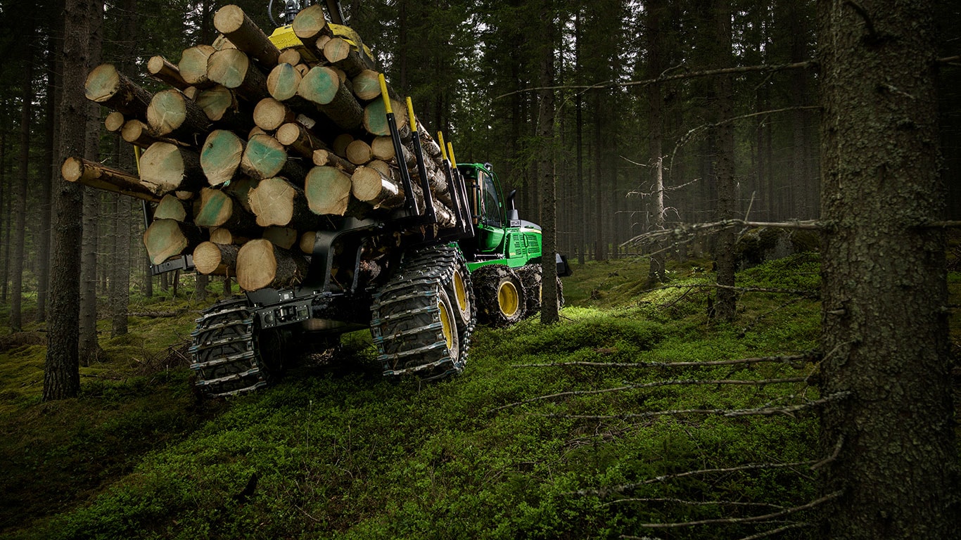 Le porteur 1510G de John Deere transporte des rondins dans la forêt