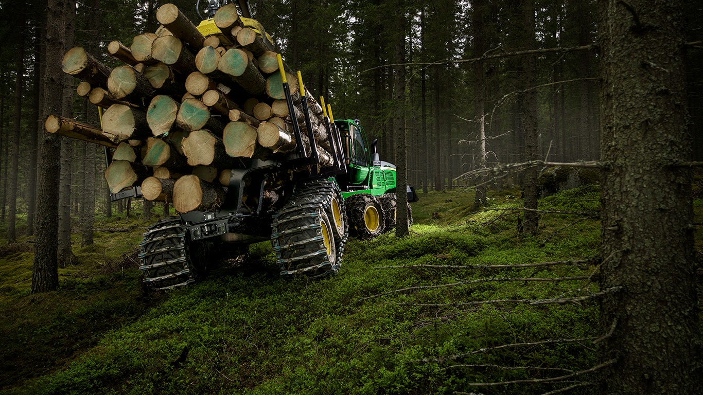 Le porteur 1510G de John Deere transporte des rondins dans la forêt