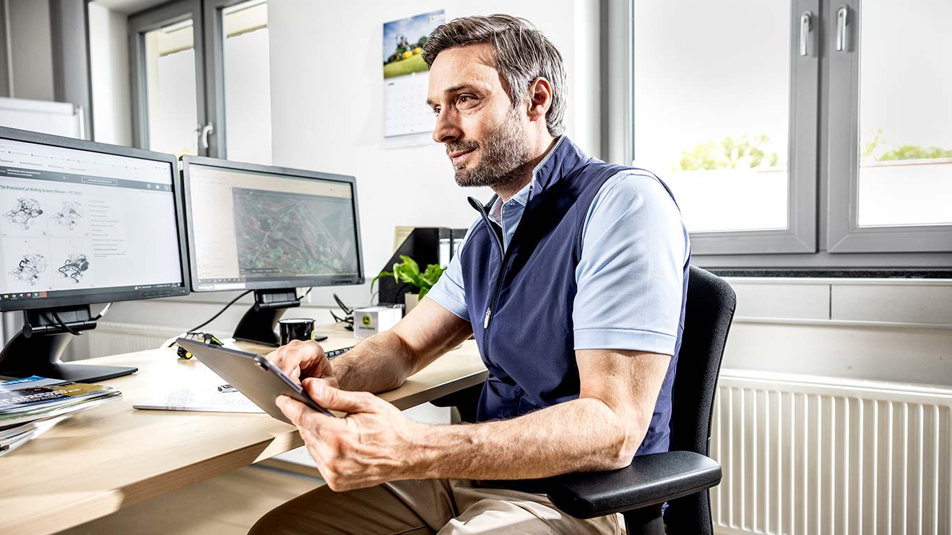 Greenkeeper en chef utilisant sa tablette au bureau.
