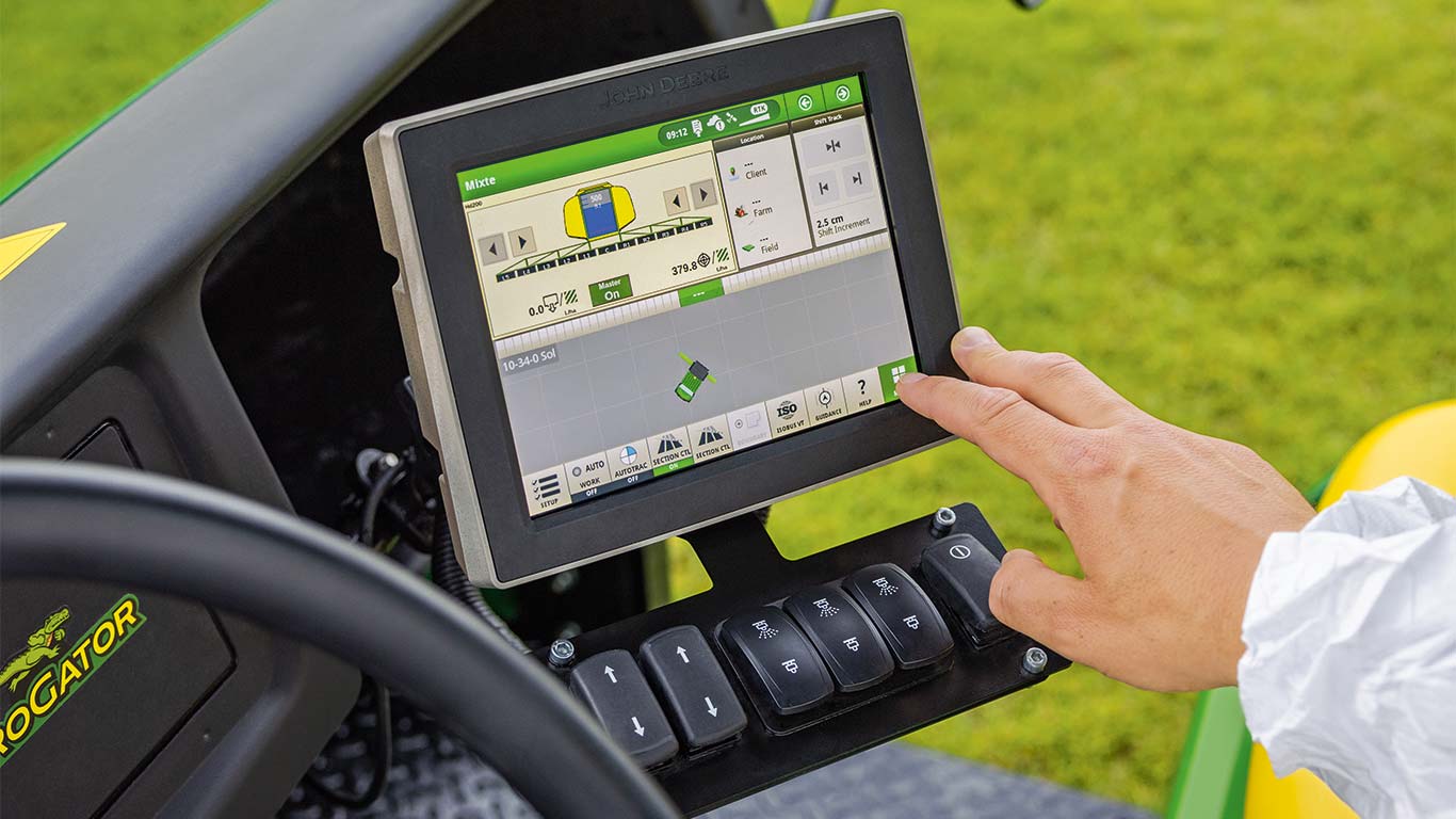 Greenkeeper utilisant la console de sa tondeuse John Deere pour adapter la machine à sa tâche en cours.