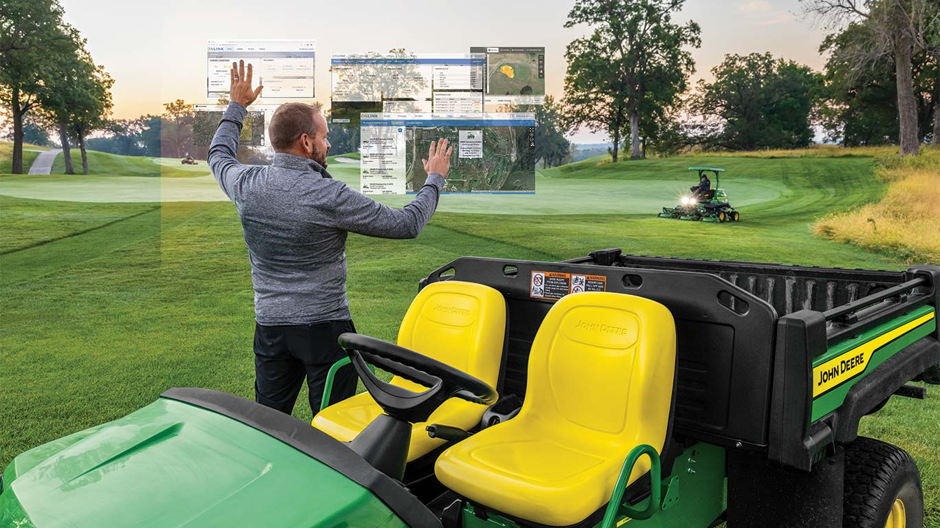 Greenkeeper utilisant une console imaginaire d’entretien des greens sur un terrain de golf.