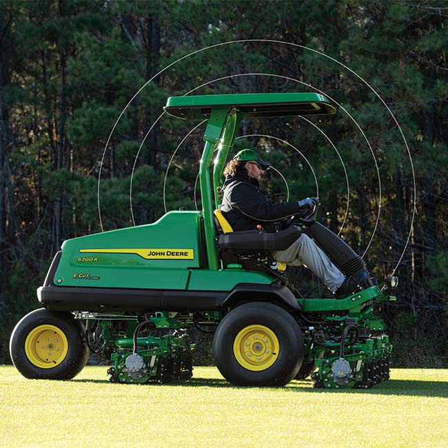 Greenkeeper travaillant sur un gazon avec une tondeuse de fairway John Deere et utilisant des technologies connectées.